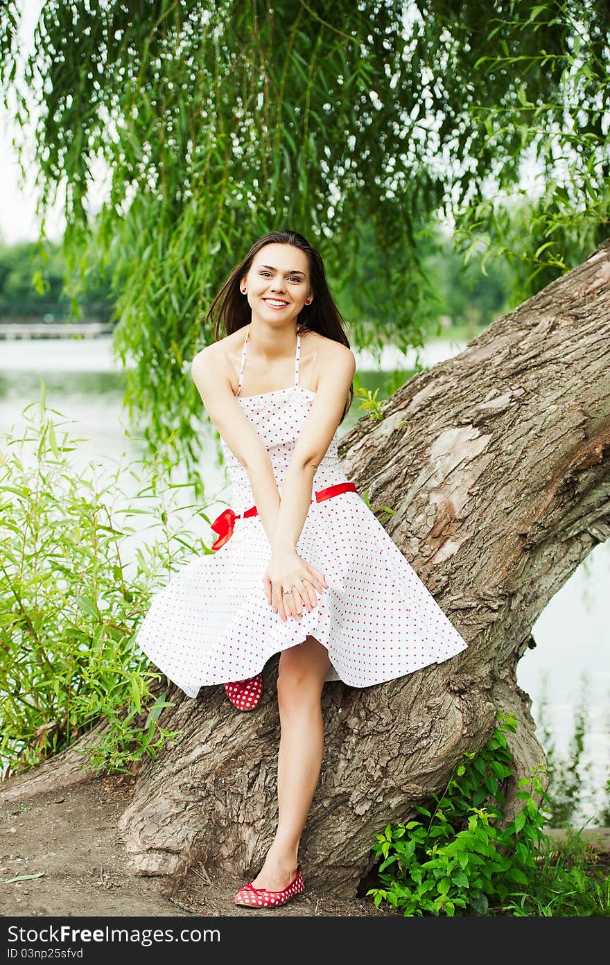 Portrait of a smiling young female model posing in a park - Outdoor