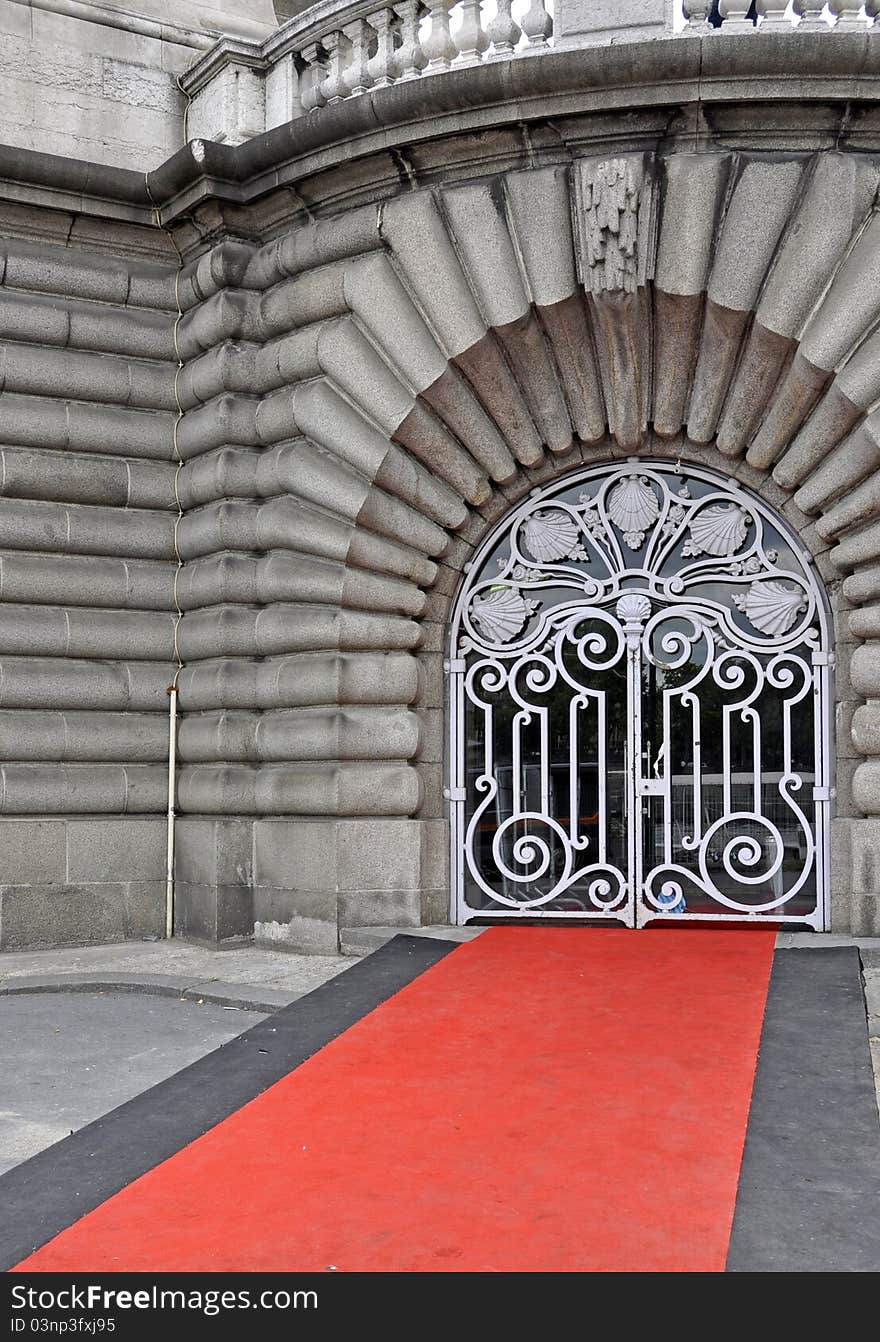 Red carpet leading up to an ornate metal gate