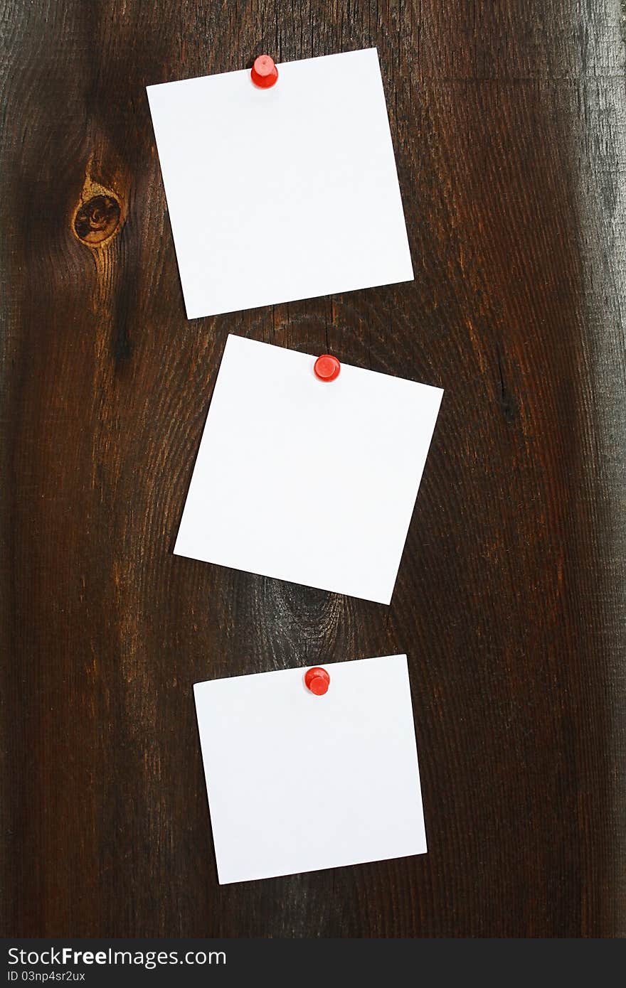 Three white stickers on a wooden background