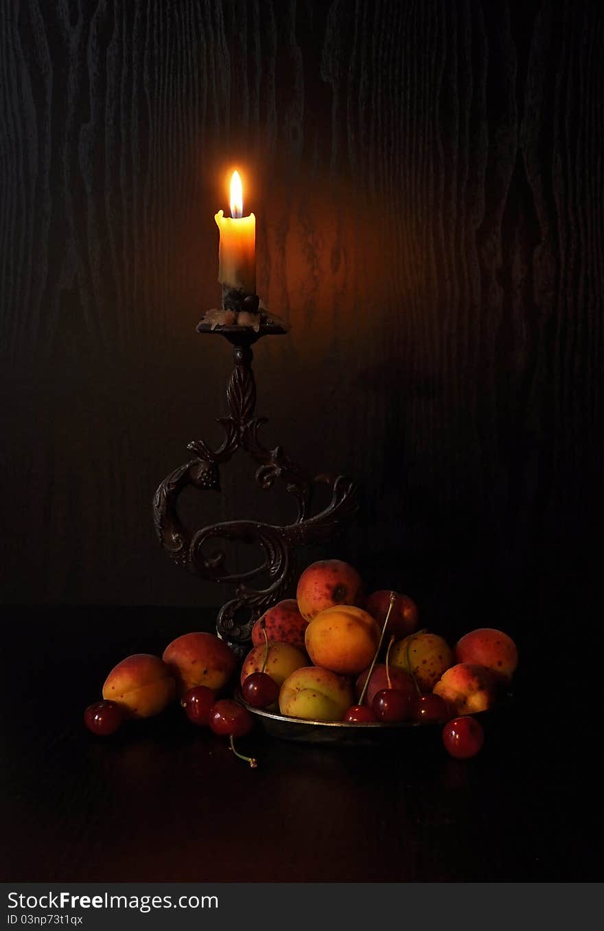 Burning candle with berries, apricots and cherries. Burning candle with berries, apricots and cherries