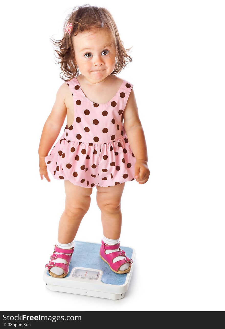 A little girl is standing on the scales. Isolated on a white background