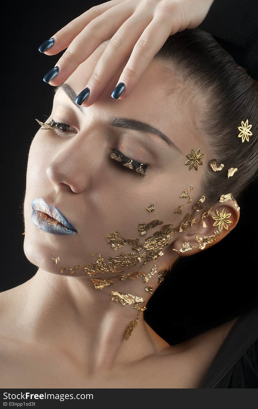 Close-up portrait of beautiful brunette with golden glamor make-up