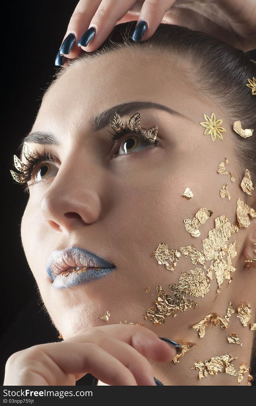 Close-up portrait of beautiful brunette with golden glamor make-up