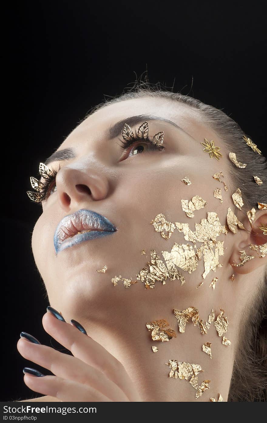 Close-up portrait of beautiful brunette with golden glamor make-up