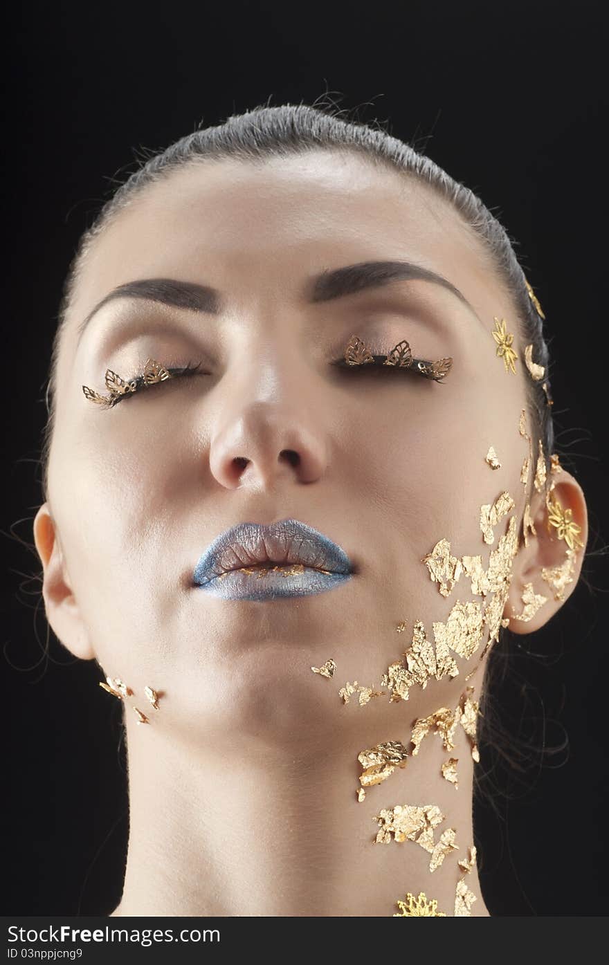 Close-up portrait of beautiful brunette with golden glamor make-up