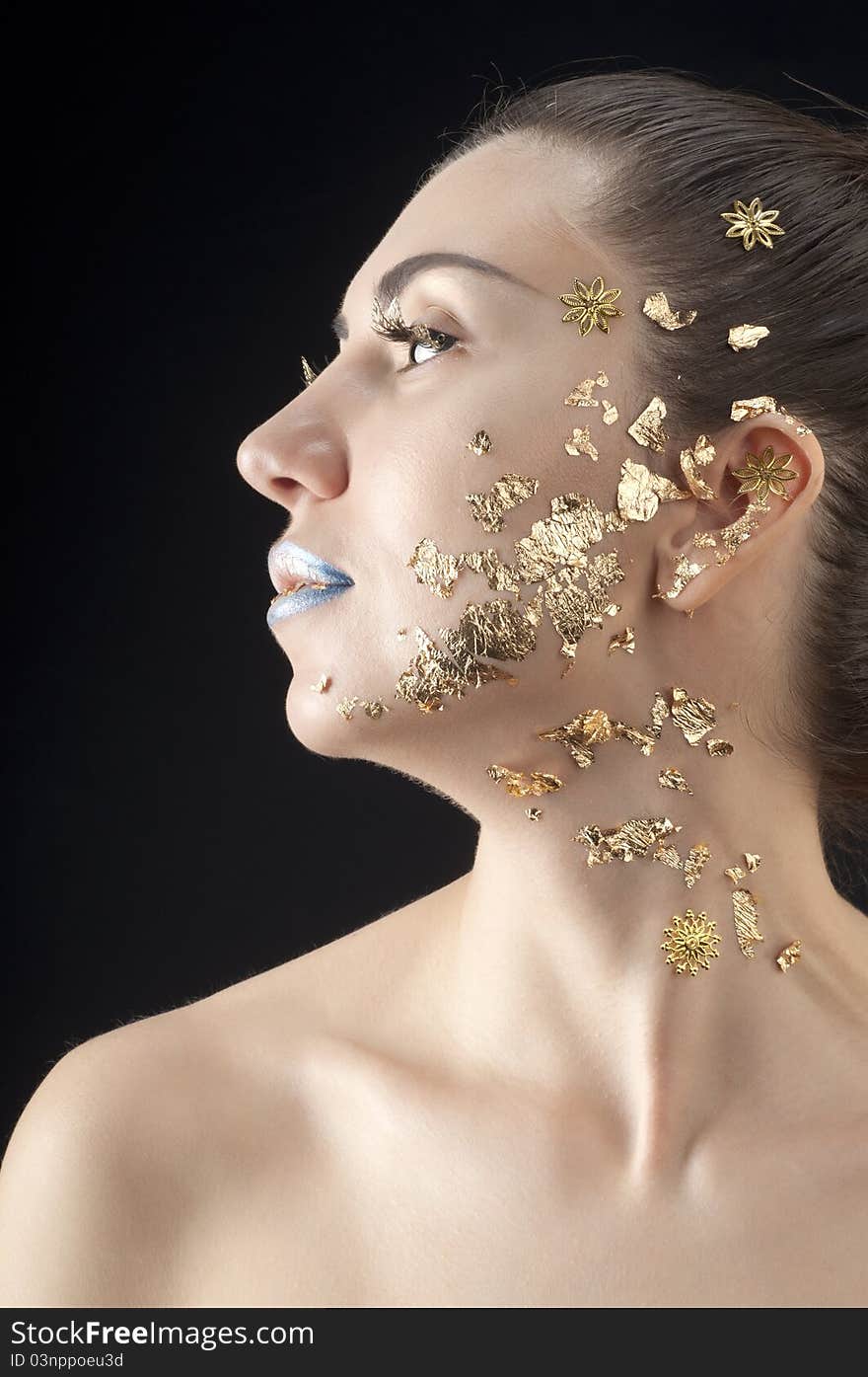 Close-up portrait of beautiful brunette with golden glamor make-up