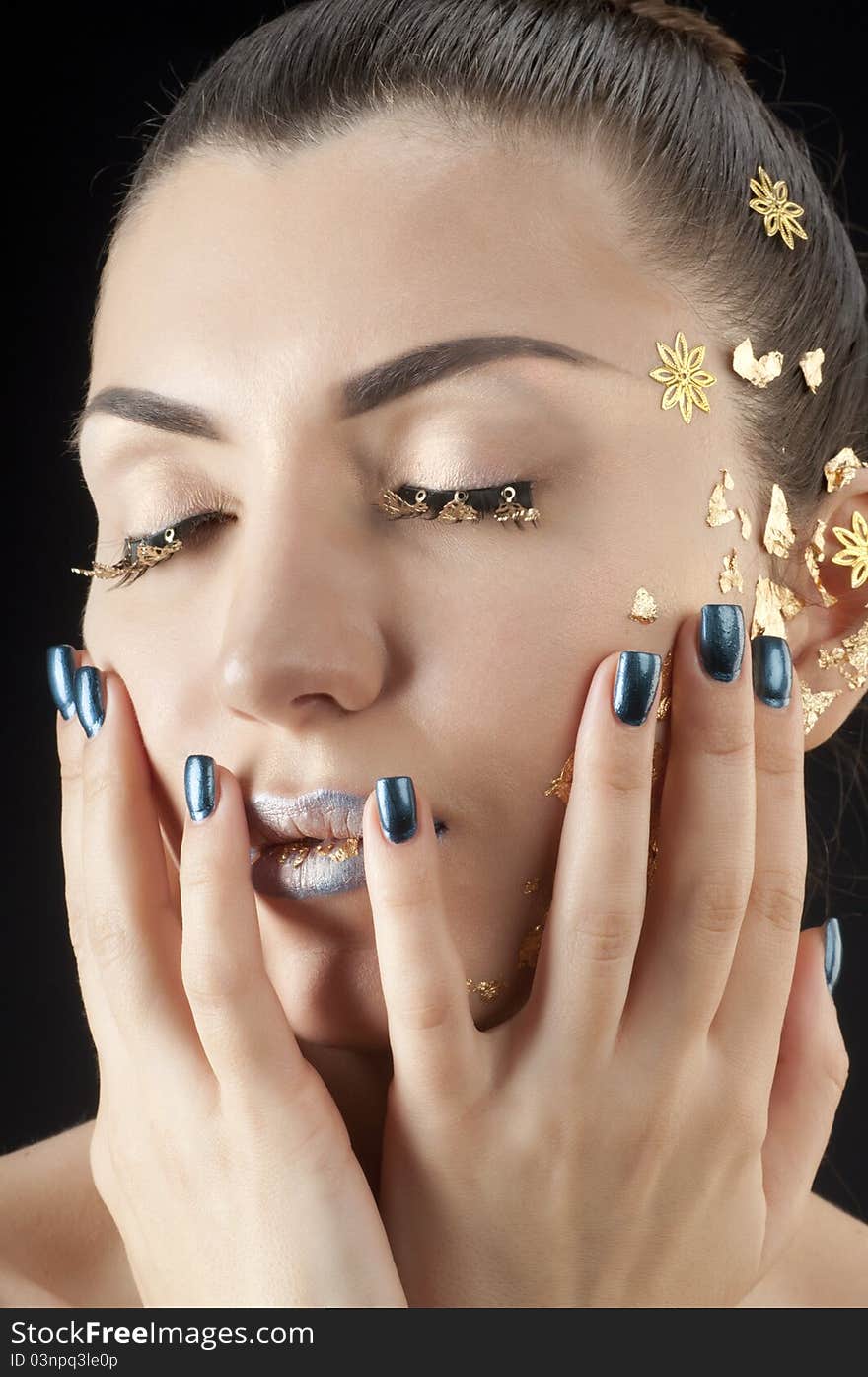 Close-up portrait of beautiful brunette with golden glamor make-up