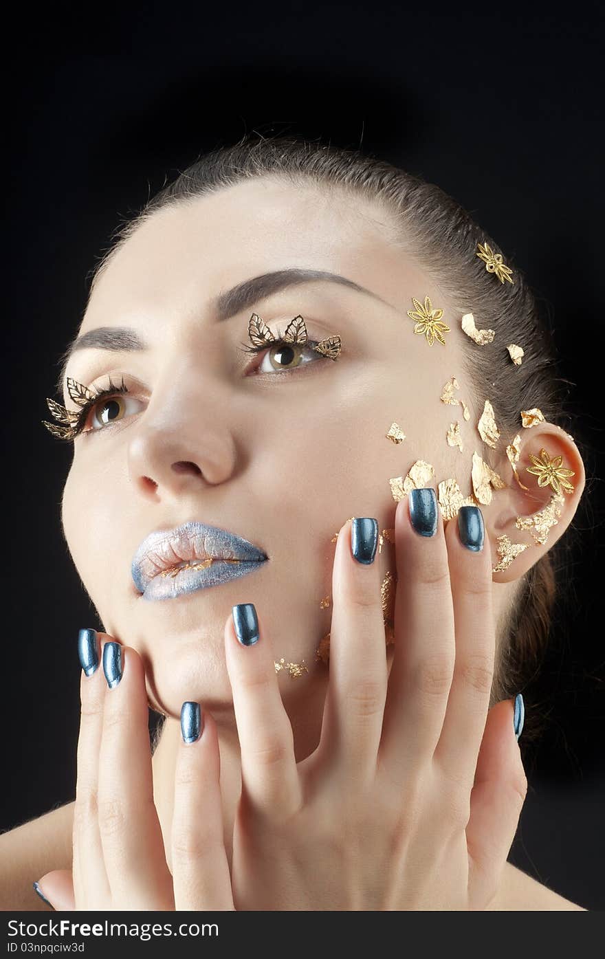 Close-up portrait of beautiful brunette with golden glamor make-up