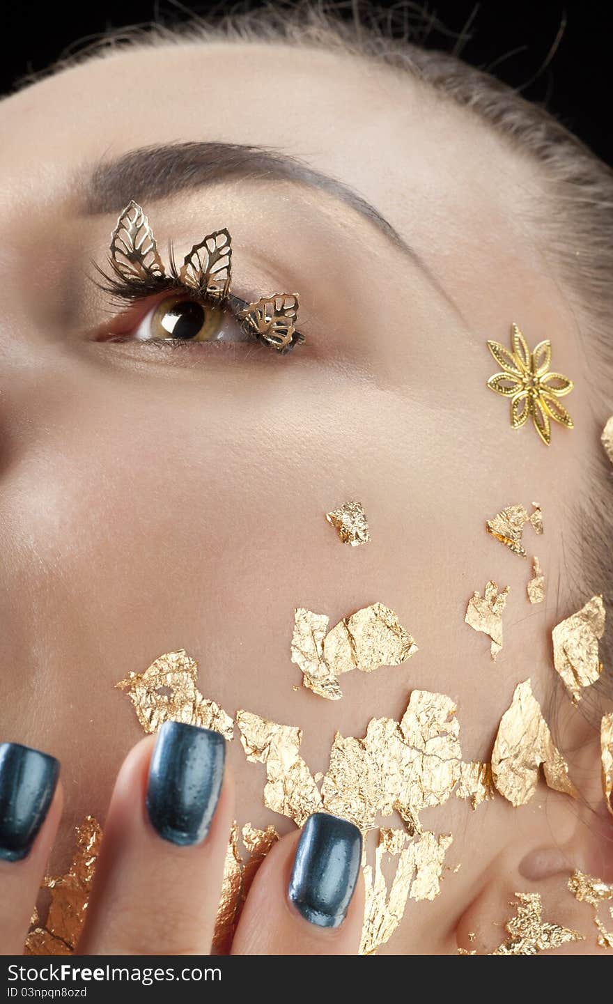 Close-up portrait of beautiful brunette with golden glamor make-up