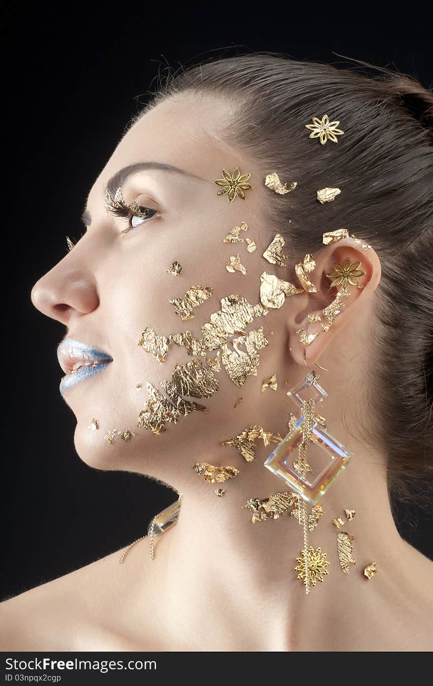 Close-up portrait of beautiful brunette with golden glamor make-up