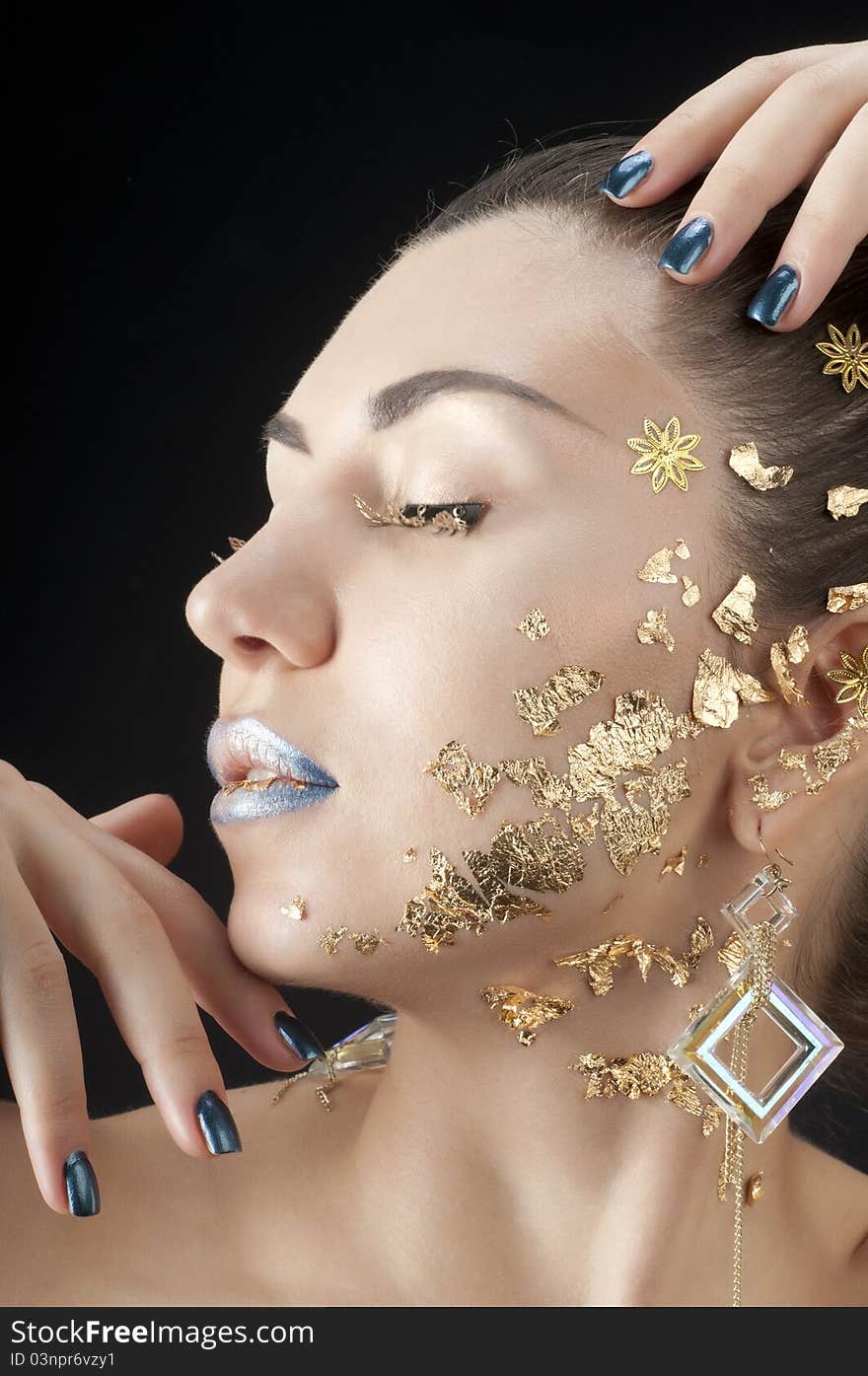 Close-up portrait of beautiful brunette with golden glamor make-up