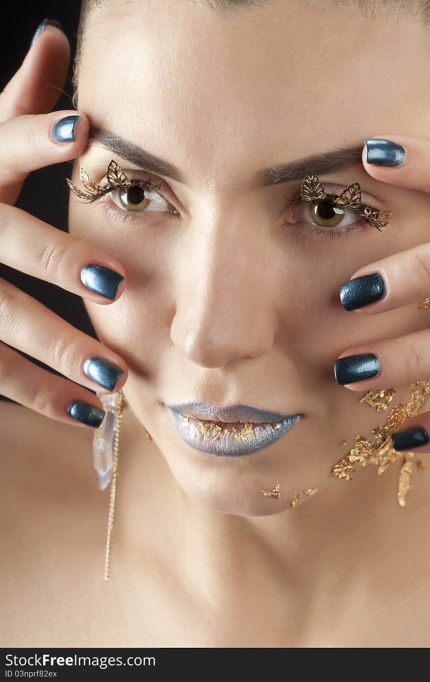 Close-up portrait of beautiful brunette with golden glamor make-up