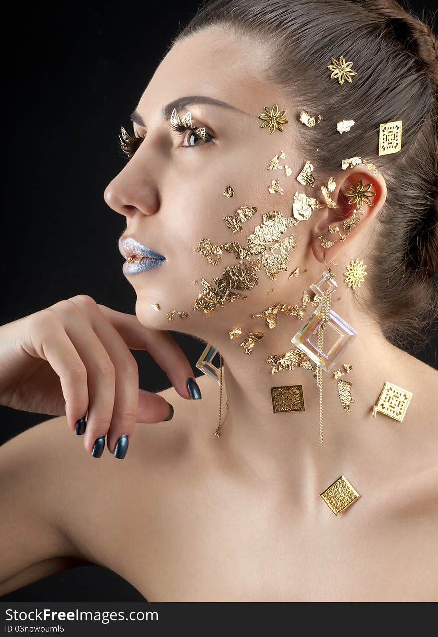 Close-up portrait of beautiful brunette with golden glamor make-up