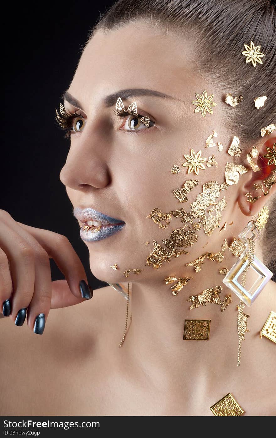 Close-up portrait of beautiful brunette with golden glamor make-up