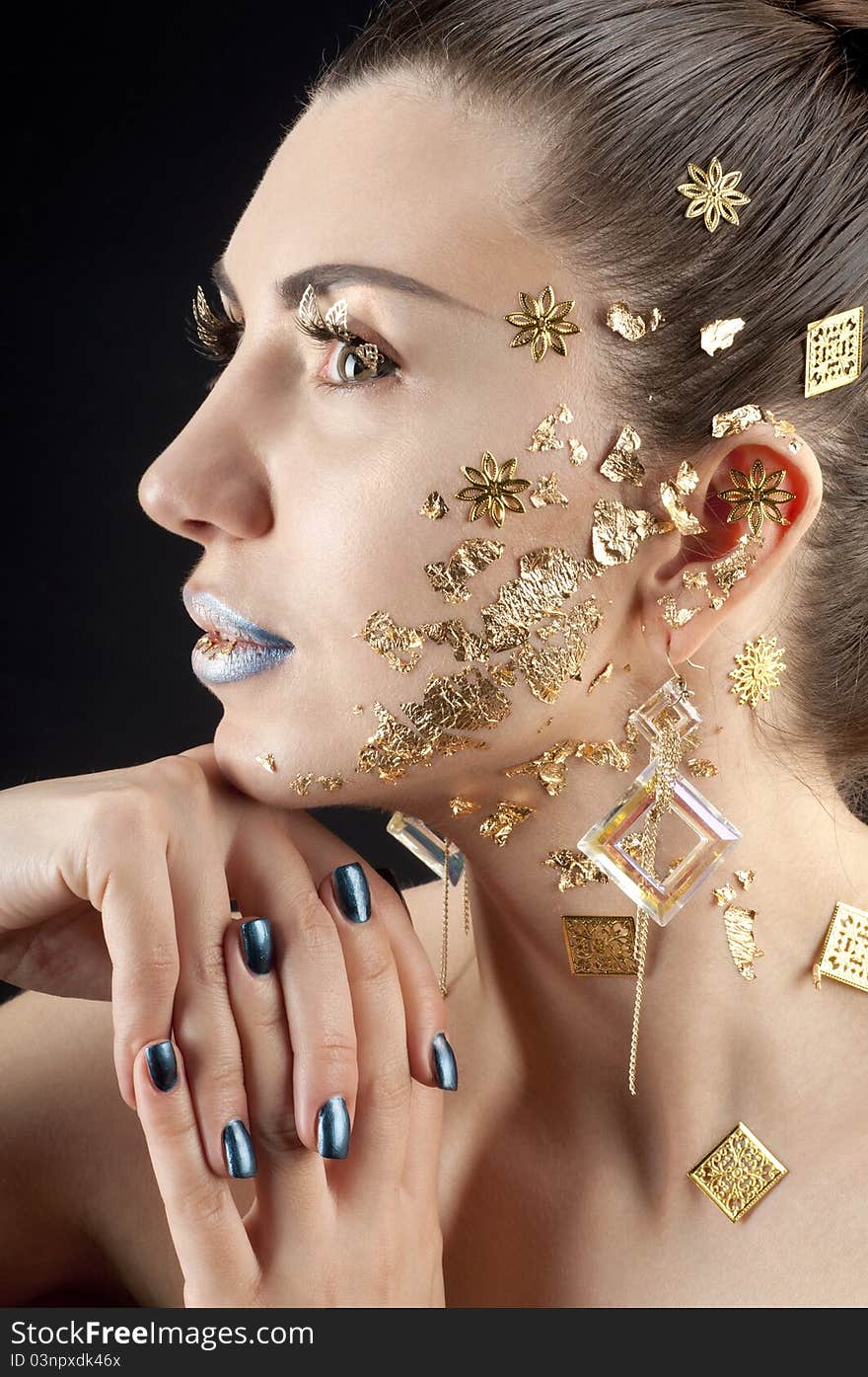 Close-up portrait of beautiful brunette with golden glamor make-up