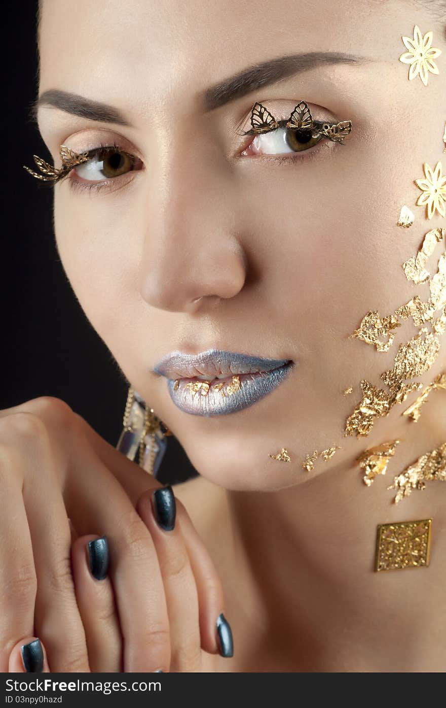 Close-up portrait of beautiful brunette with golden glamor make-up