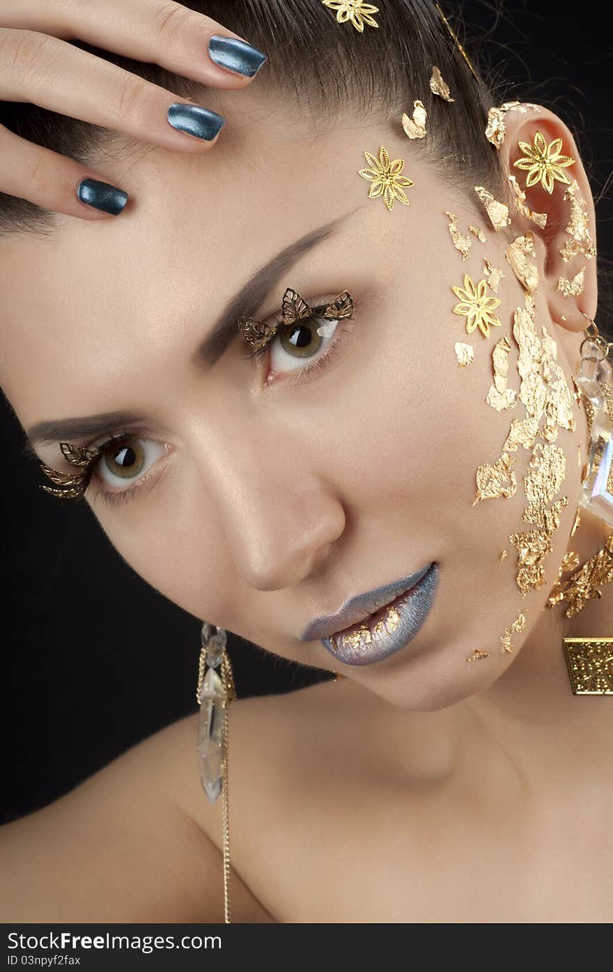 Close-up portrait of beautiful brunette with golden glamor make-up