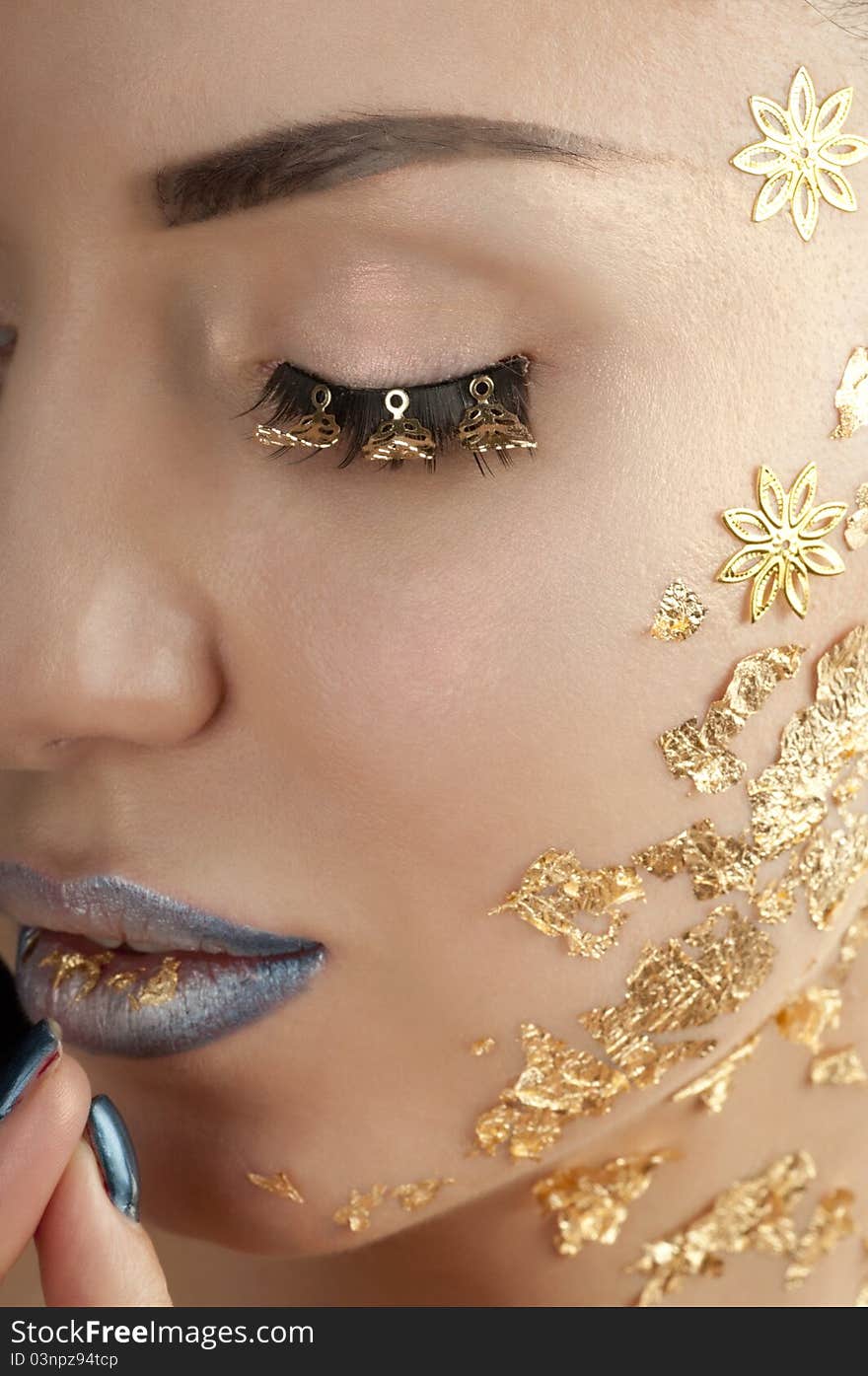 Close-up portrait of beautiful brunette with golden glamor make-up