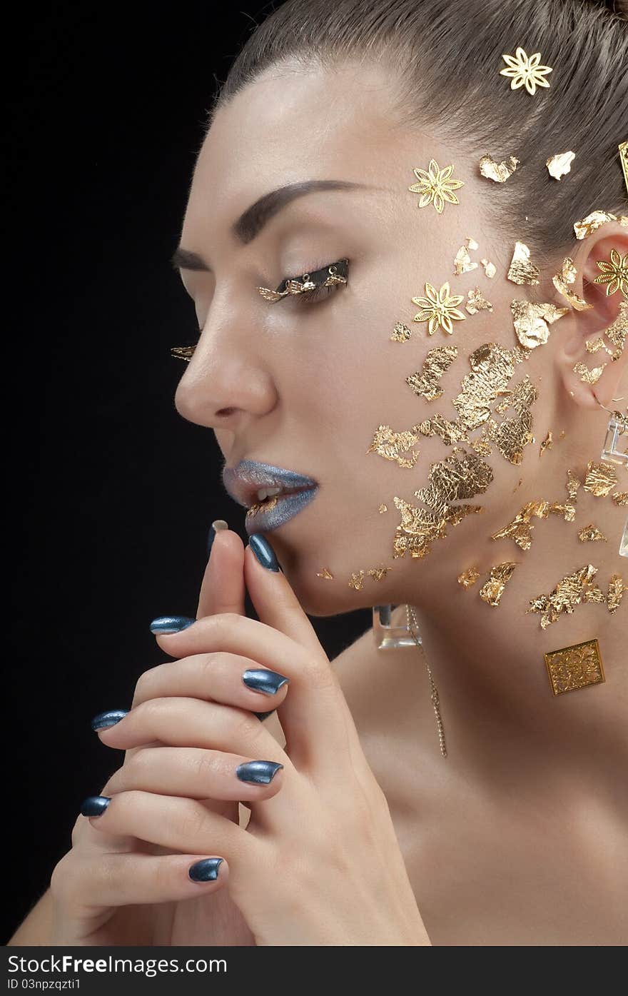 Close-up portrait of beautiful brunette with golden glamor make-up