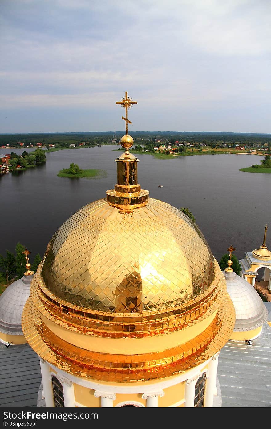 The golden cupola of church in the sky and lake