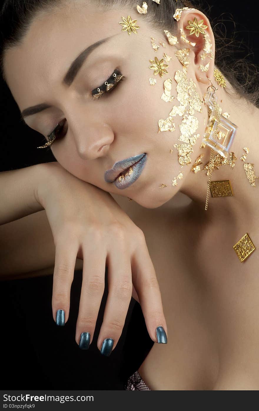 Close-up portrait of beautiful brunette with golden glamor make-up