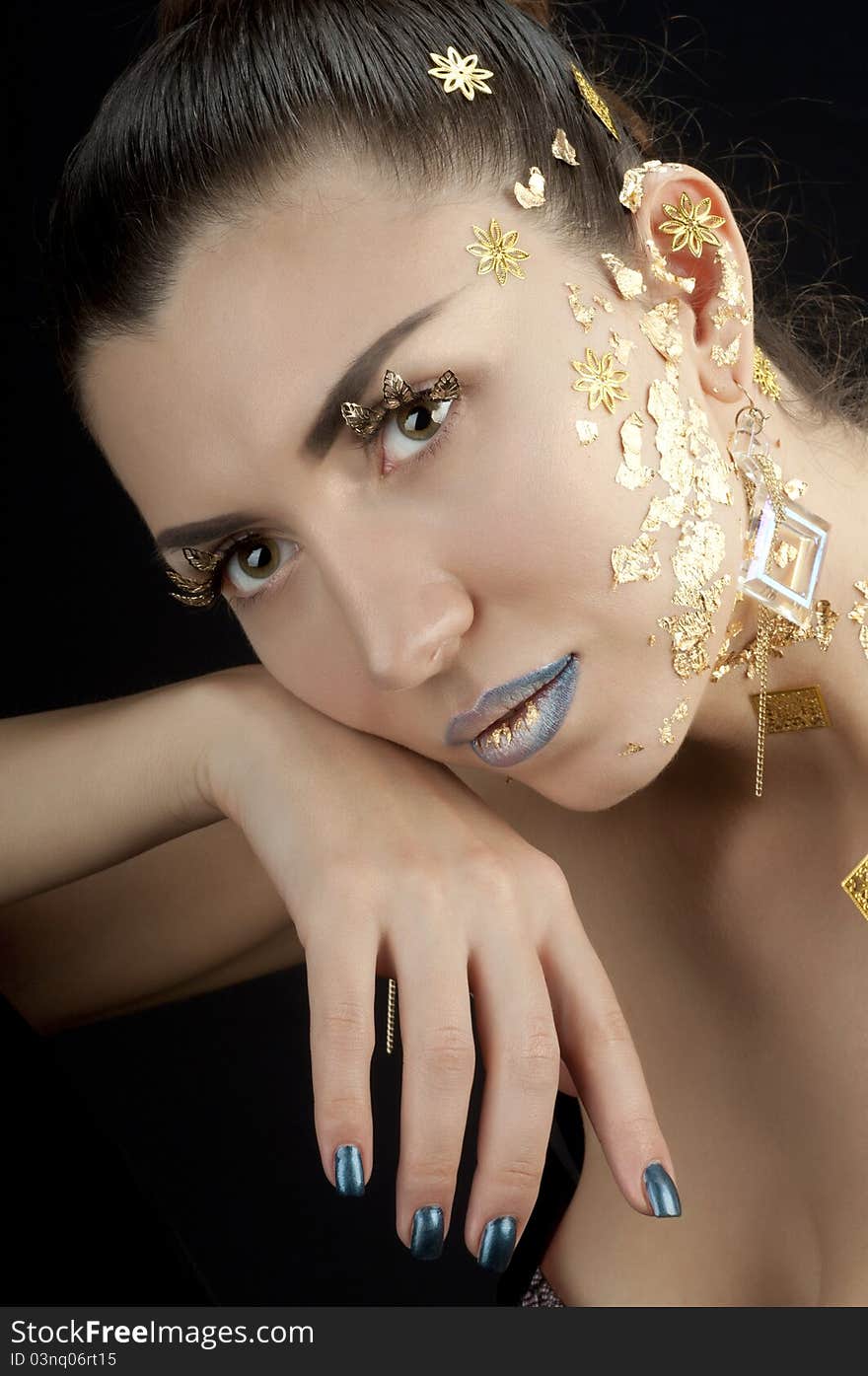 Close-up portrait of beautiful brunette with golden glamor make-up