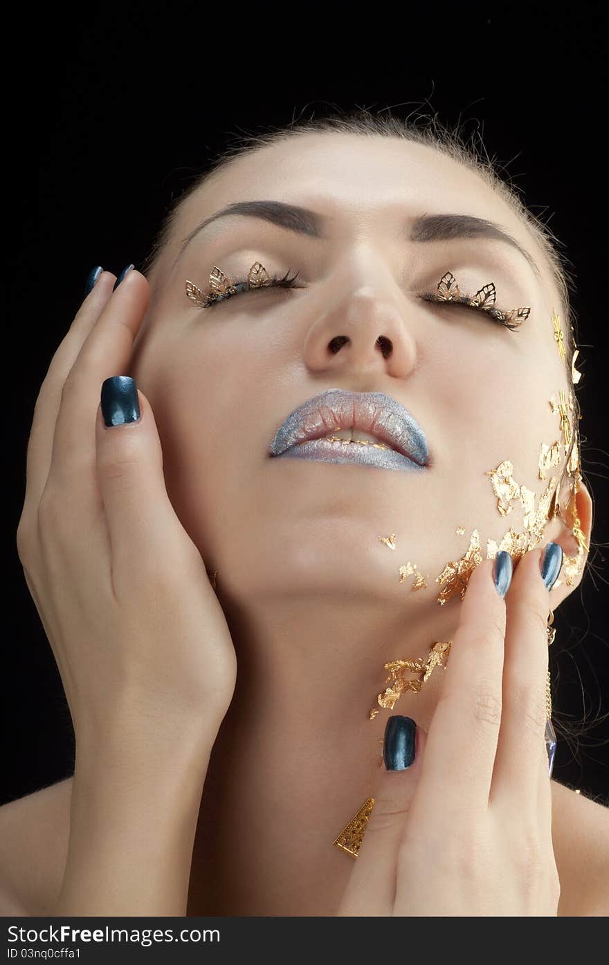 Close-up portrait of beautiful brunette with golden glamor make-up