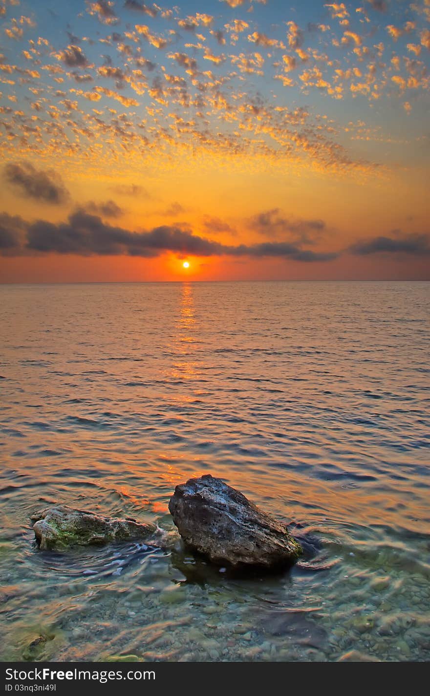 The stones protruding from the water at sunset. The stones protruding from the water at sunset