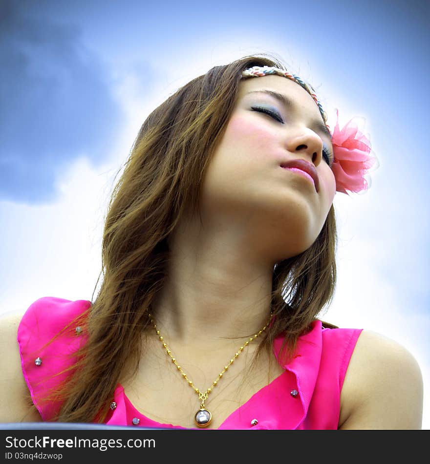 Beautiful Asian woman relaxing over the blue sky. Beautiful Asian woman relaxing over the blue sky.