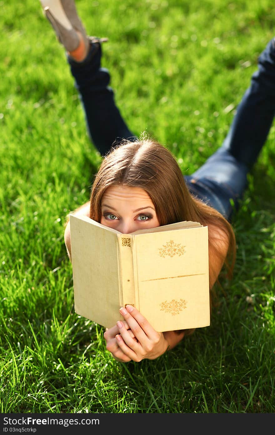 Woman reading book in the park on the grass. Woman reading book in the park on the grass