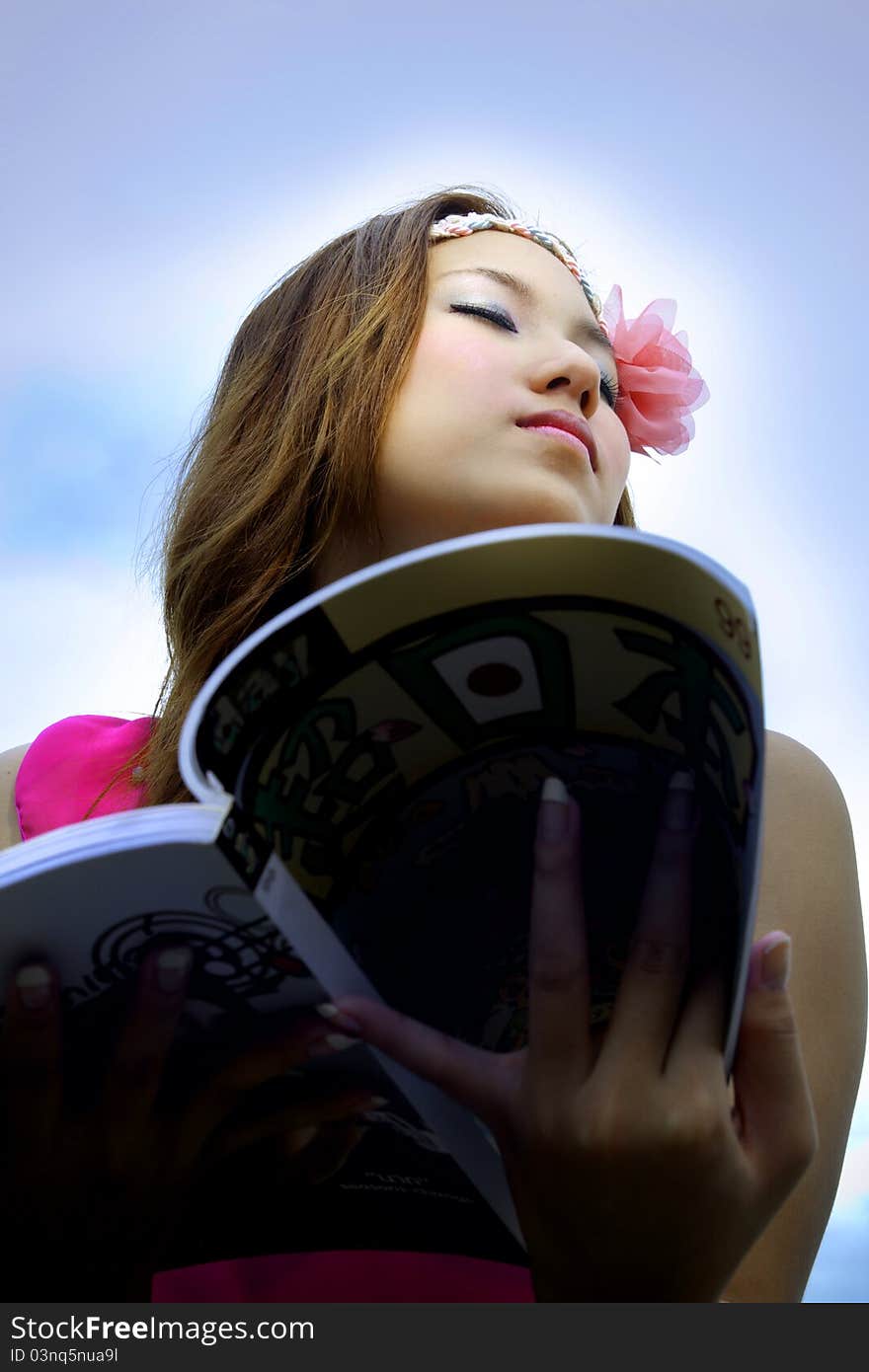 Beautiful Asian woman relaxing over the blue sky. Beautiful Asian woman relaxing over the blue sky.