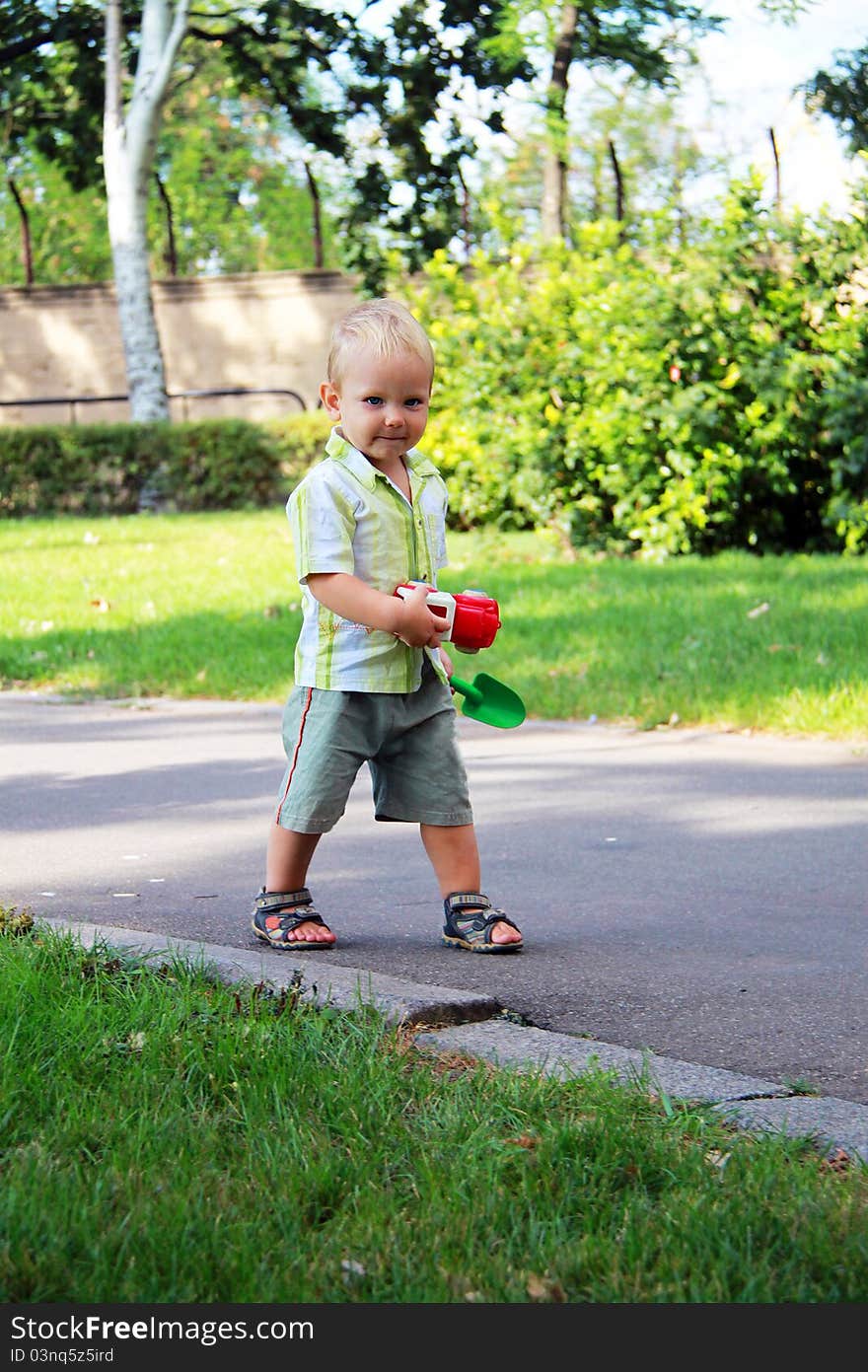 A little boy walks in the park