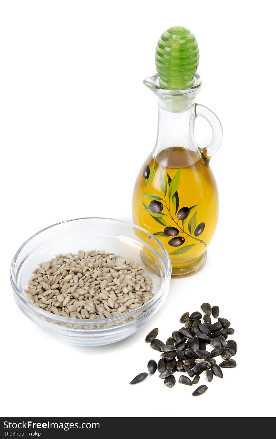 Oil in bottle and sunflower seeds on white background. Oil in bottle and sunflower seeds on white background