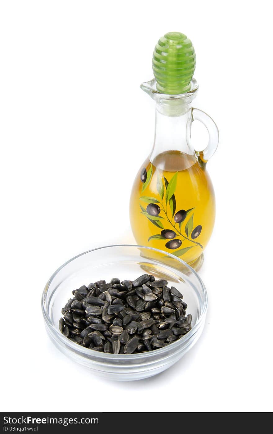 Oil in bottle and sunflower seeds on white background. Oil in bottle and sunflower seeds on white background