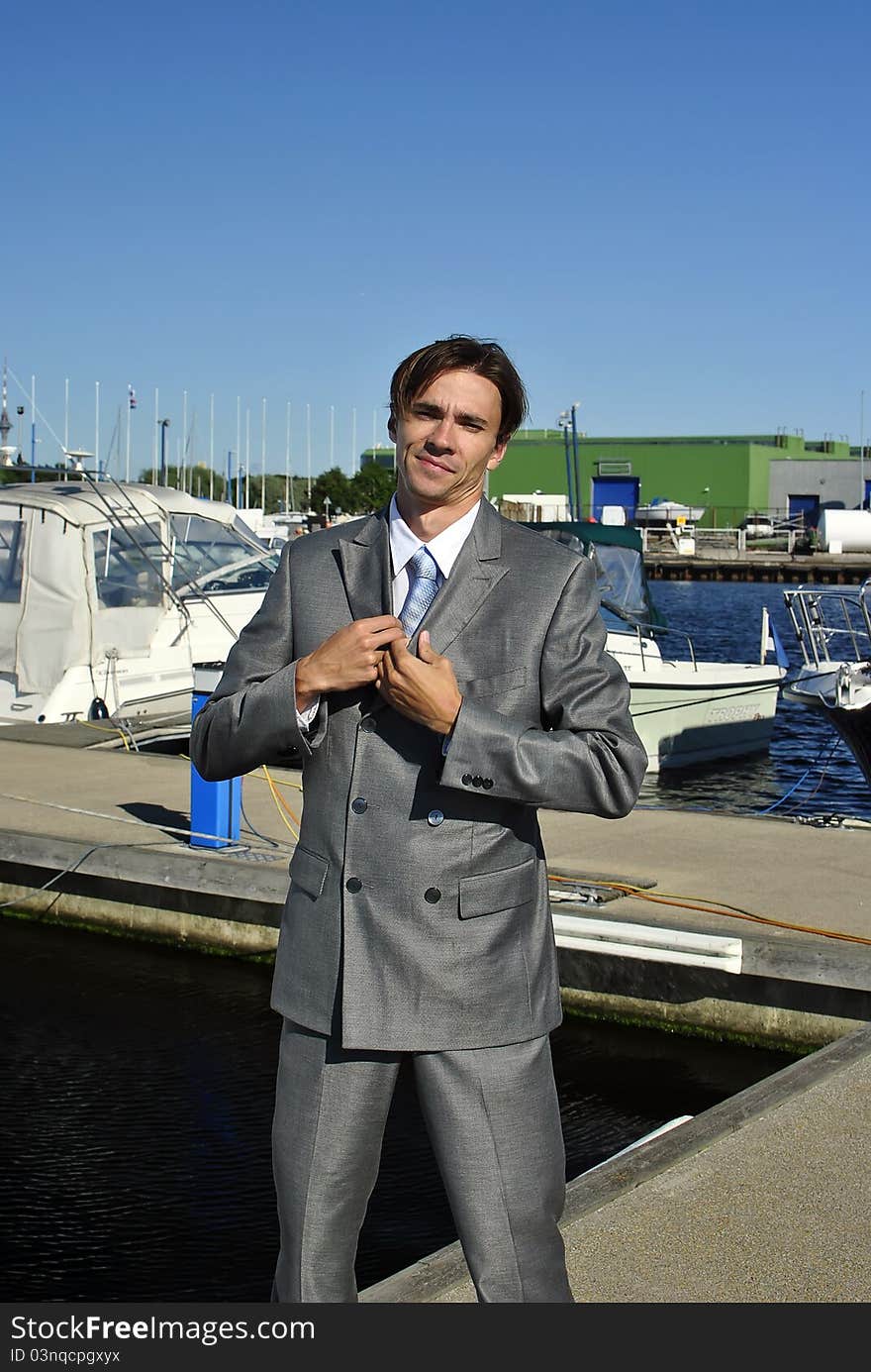 Man in a gray business suit straightens his tie