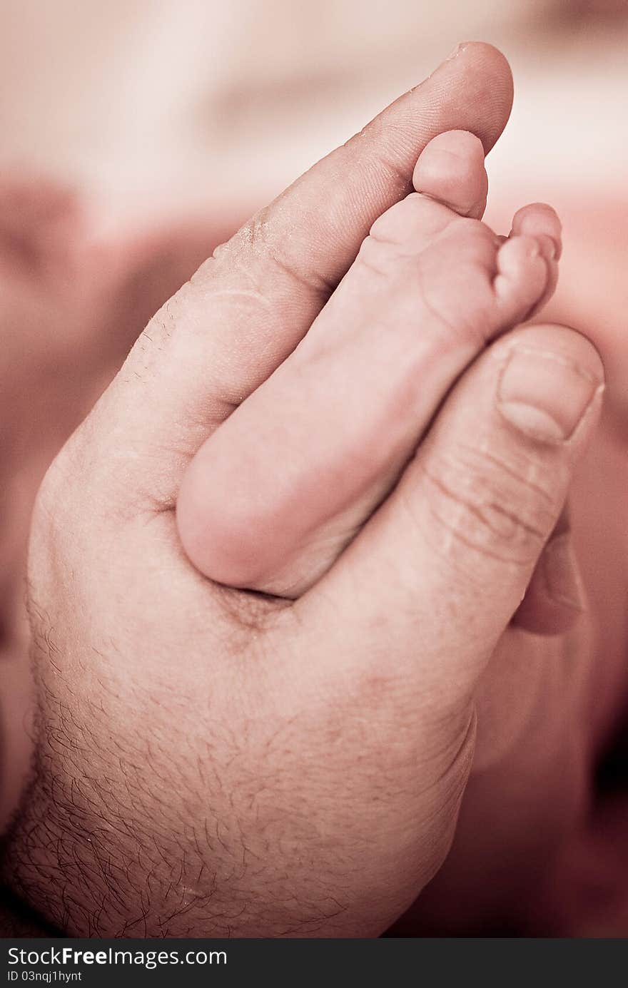 Baby's foot in mother hands closeup. Baby's foot in mother hands closeup