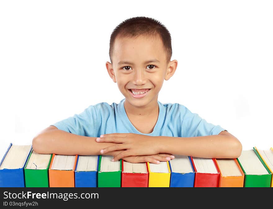 Young boy smiling on top of his books