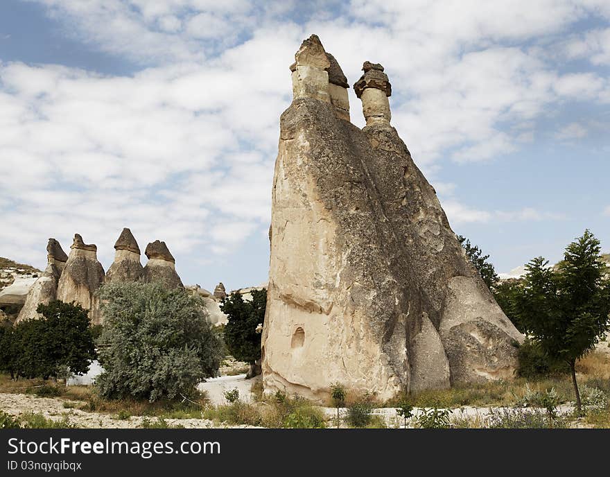 Landscape of groups of limestone wind weathered to what are known as fairy chimneys. horizontal with crop area and copy space, cloudy blue sku and wilderness environment. Landscape of groups of limestone wind weathered to what are known as fairy chimneys. horizontal with crop area and copy space, cloudy blue sku and wilderness environment