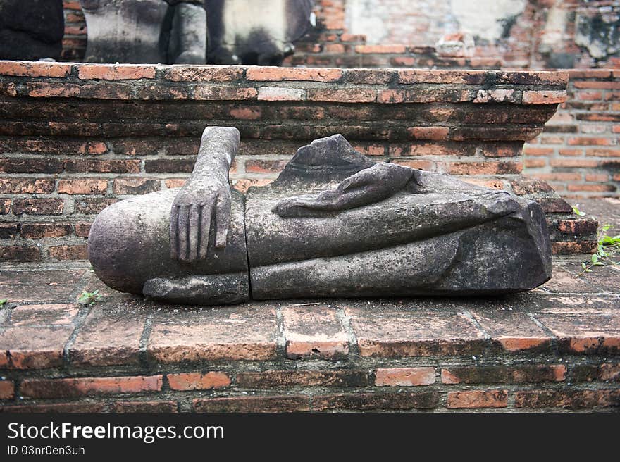 A ruined stone Buddha statue in Ayutthaya, Thailand. A ruined stone Buddha statue in Ayutthaya, Thailand