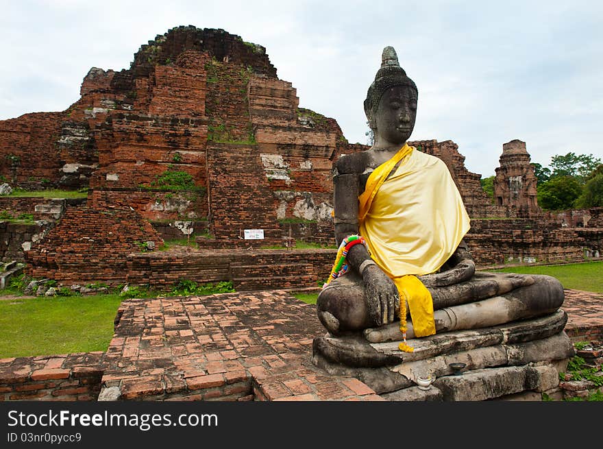 A buddha statue and ruins of a beautiful ancient wat in Ayutthaya, Thailand. A buddha statue and ruins of a beautiful ancient wat in Ayutthaya, Thailand