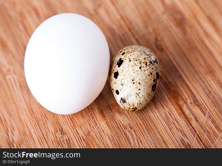 Two eggs on the wooden cutting board