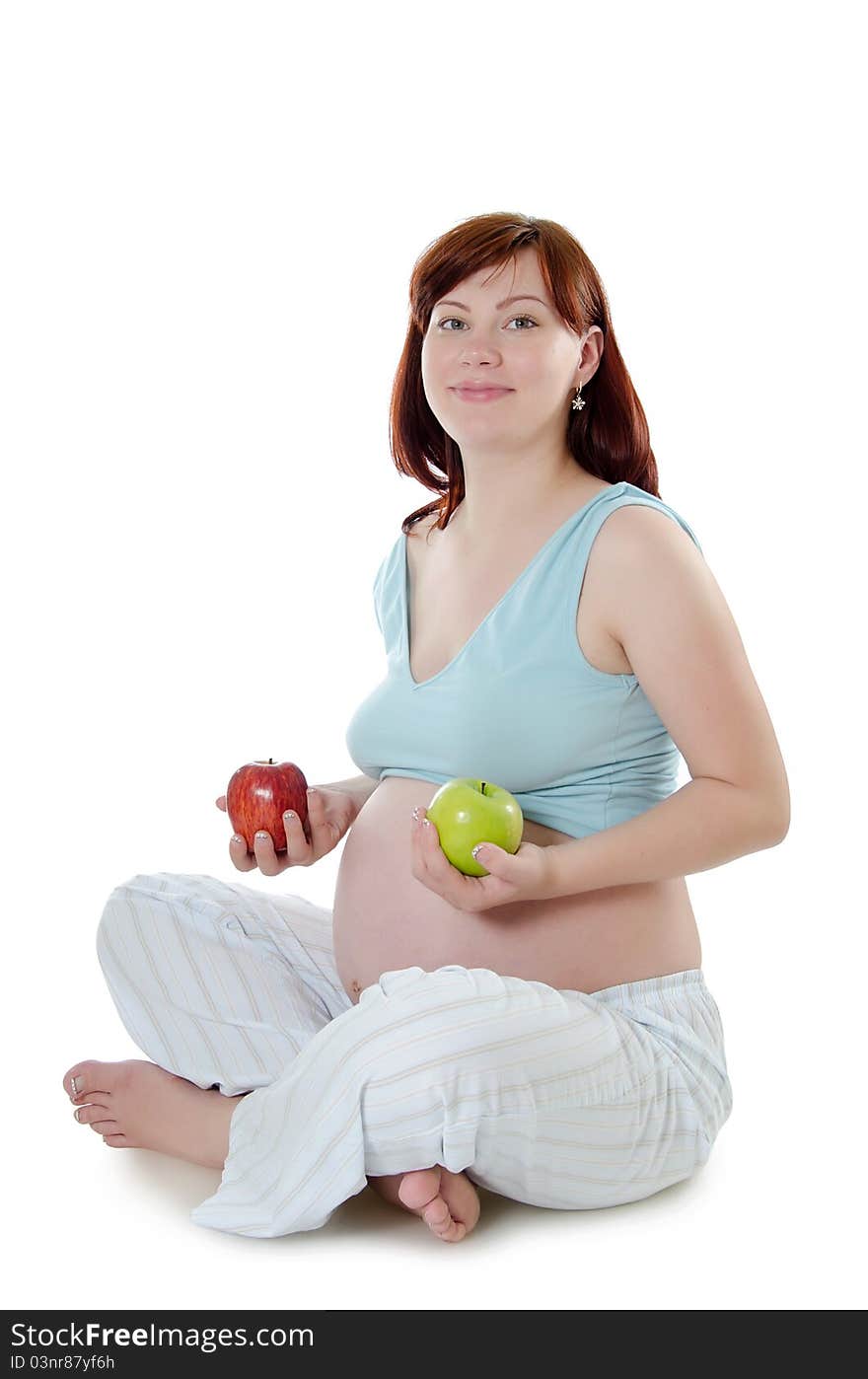 The pregnant woman with an apple on white