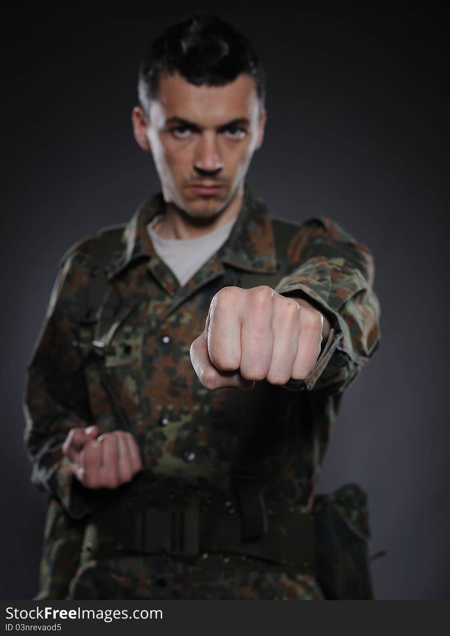 Portrait of soldier in camouflage and ammunition fighting. focus on the fist. Portrait of soldier in camouflage and ammunition fighting. focus on the fist