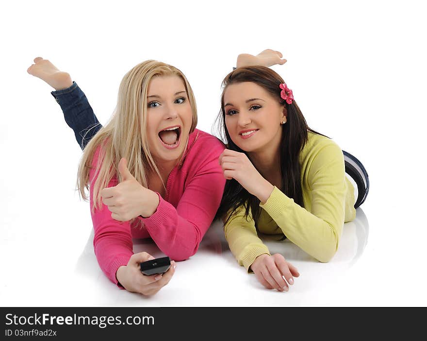 Two young pretty women friends watching television and switching channels on remote control. Two young pretty women friends watching television and switching channels on remote control