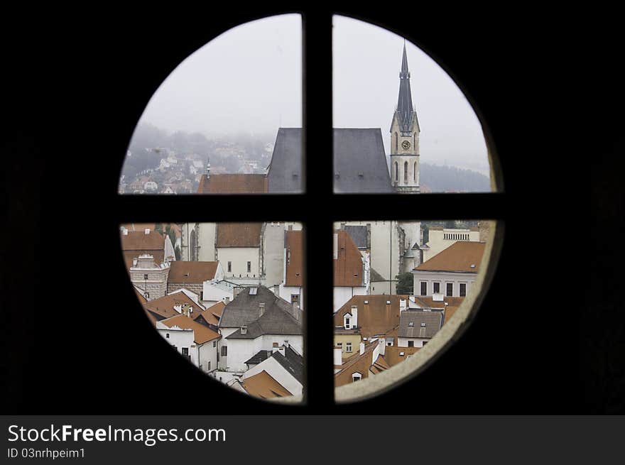 Looking through a round window out on a historic city in Cesky Krumlov, Europe. Looking through a round window out on a historic city in Cesky Krumlov, Europe.