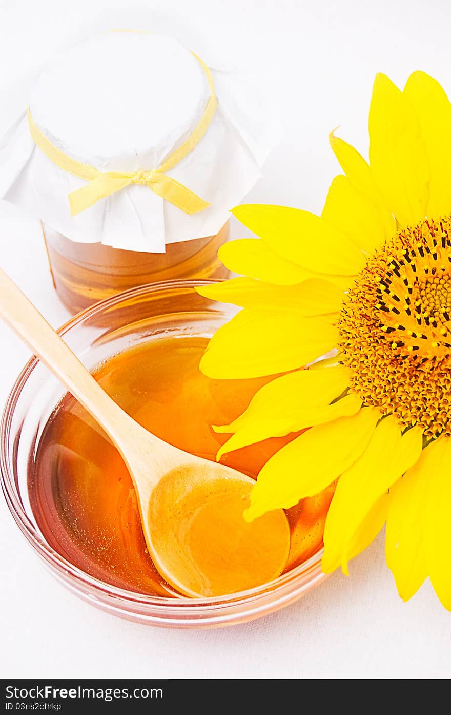 Honey in jar with wooden spoon and sunflower. Honey in jar with wooden spoon and sunflower