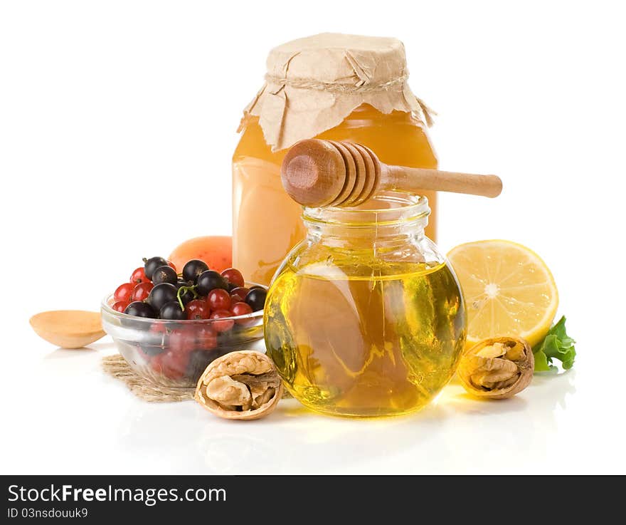 Glass jar full of honey, lemon and berry isolated on white background