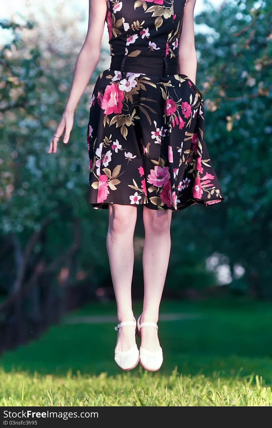 Girl in a dress flying to air over a green glade. Girl in a dress flying to air over a green glade