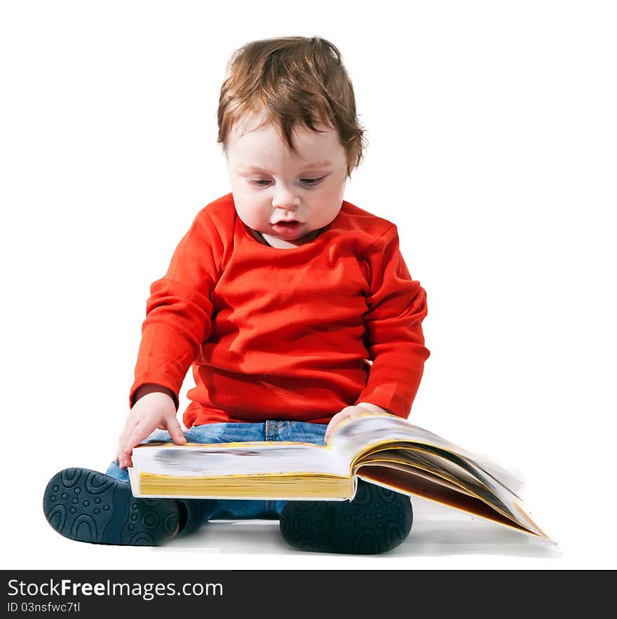 Little boy reads the book interestedly on a white background