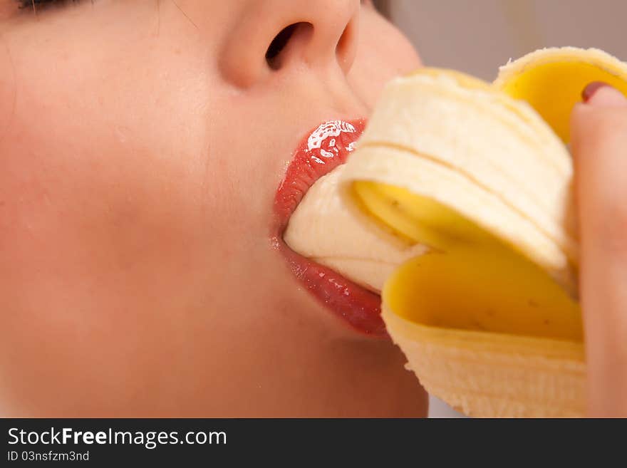 Young woman eating banana